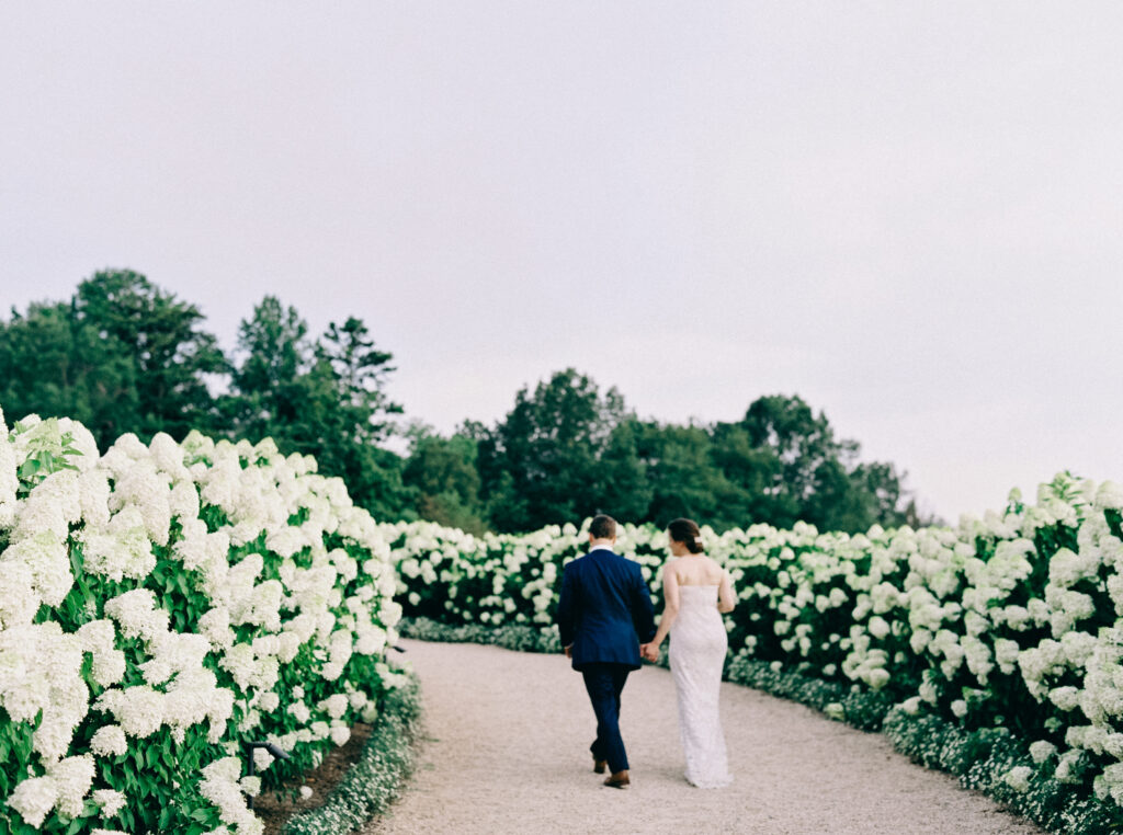 Image of a bridal couple walking hydrangea at Pippin Hill one of the Best East Coast Wedding Venues