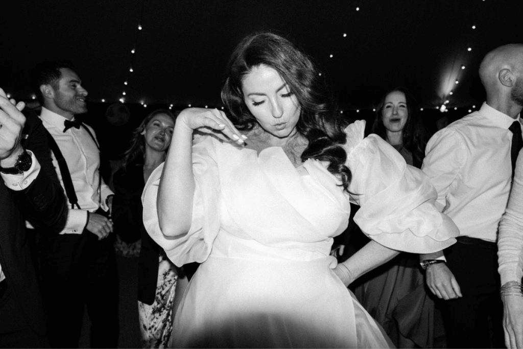 Black and White image of a bride dancing at her wedding date reception showcasing a personality image from a wedding photographer shot list
